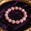 Rhodochrosite natural stone bracelet on dark velvet